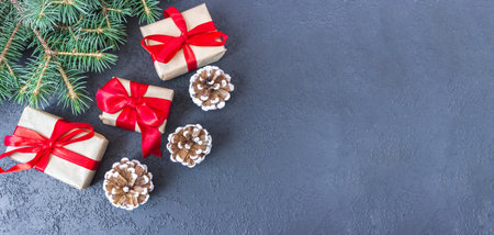Festive gift boxes with fir branches and cones on a concrete background. New Year and Christmas concept. flatlay. copyspace. postcard.の写真素材