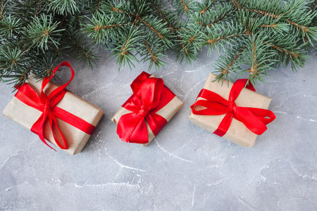Festive gift boxes with spruce branches on concrete background. The concept of New Year and Christmas. flatlay. copyspace. postcard.の写真素材