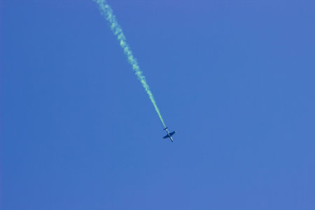 Plane with a smoke trail in the blue sky. airshow.