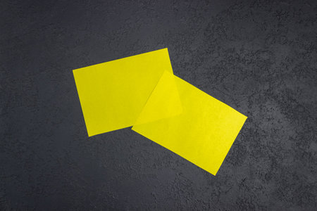 Mock up of a blank yellow sheet on a dark concrete background. Paper template for design. business...