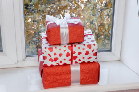 Red gift boxes on the window. The concept of preparing for the New Year and Christmas holidays.の写真素材