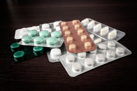 Lots of pills on a wood table.