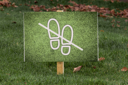 Sign on green grass with a warning Do not walk on lawns.の写真素材