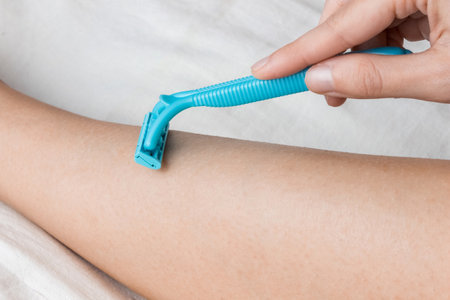 Hair removal on a female leg with a shaving machine. skincare concept.の写真素材