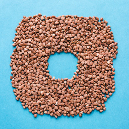 Buckwheat grains on a blue background. Space for text.