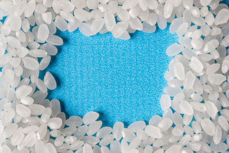 Grains of rice grit on a blue background. A healthy diet. Space for text.の写真素材