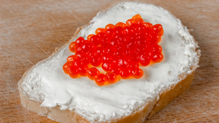 Red salmon caviar on bread and butter close-up.の写真素材