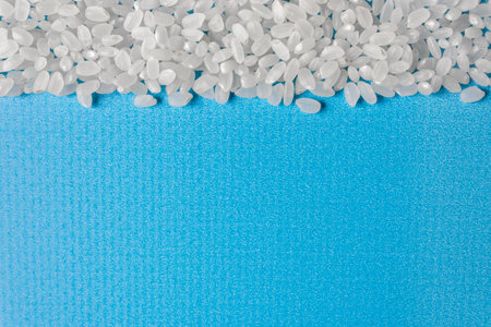 Grains of rice grit on a blue background. A healthy diet. Space for text.