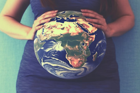 Pregnant woman with a globe instead of a belly. The concept of the miracle of life, the connection with the planet.の素材