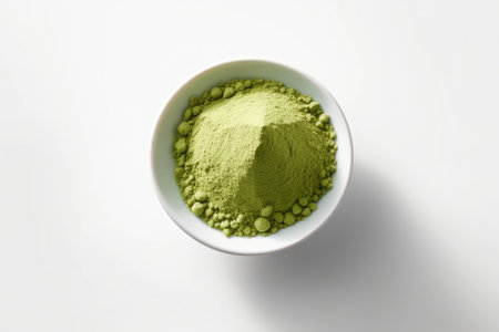 Dry matcha tea powder in a bowl on a white background, top view.の素材