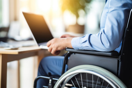 A man's laptop in a wheelchair helps his career.の素材