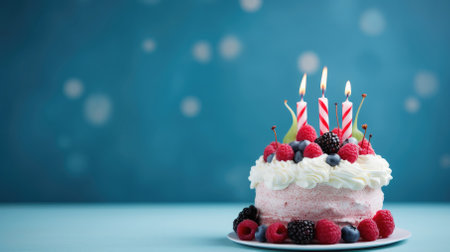 Dessert adorned with birthday candles, berries on a blue background, copy space.の素材