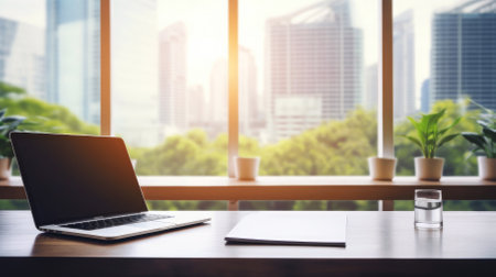 Laptop at a minimalist workspace with cityscape background.の素材