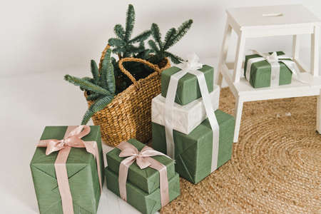 Eco friendly Christmas composition with gift boxes in craft reusable paper and natural decor . Christmas concept. Green gift boxes with white ribbons.の写真素材