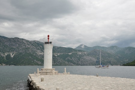 View of the lighthouse on the island and the sailboat in the bay in Montenegro, Kotorの写真素材