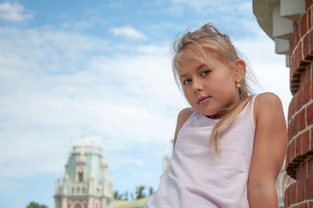 Eight-year-old beautiful girl close-up against the blue sky, Russia.の写真素材