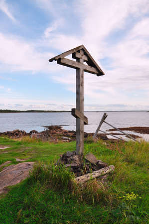 Close-up of a wooden Orthodox cross on a summer evening against the White sea, Russia.の写真素材