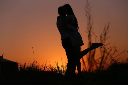 a couple in love on the background of the sunset, free space for textの写真素材