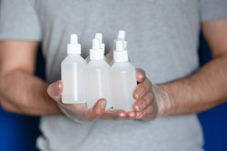 A man wearing gloves with hand antiseptic to protect against coronavirus, close-upの写真素材