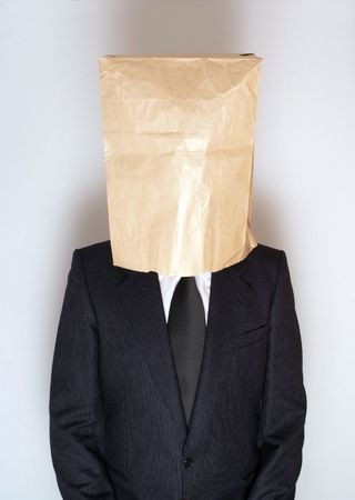 Businessman with paper bag over his headの写真素材
