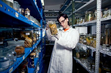 Biologist holding jar with animals in formalinの写真素材