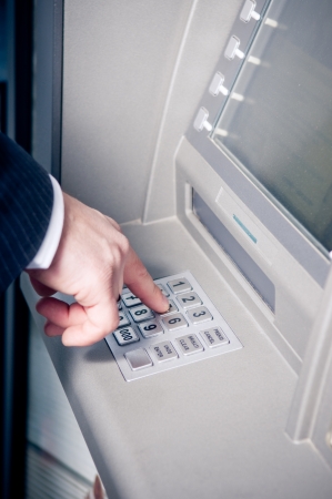 Hand entering personal identification number on ATM dial panel の写真素材