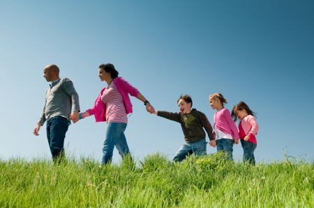 Family walking outdoors holding hands の写真素材