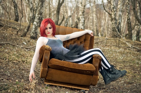 Redhead girl on an armchair in the forest  の写真素材