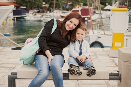Mother and son sitting in harbor の写真素材