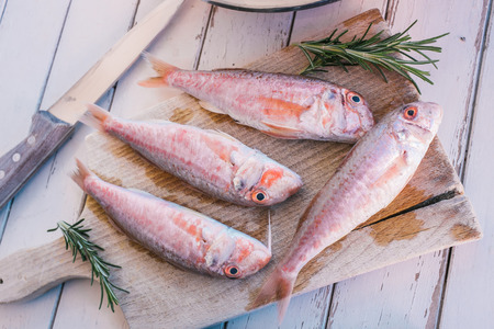 Mullet fish and rosemary on wooden tableの写真素材