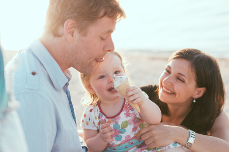 Happy family of three on the beachの写真素材