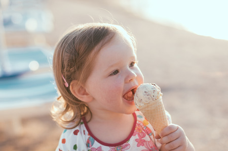 Cute little girl eating ice-creamの写真素材