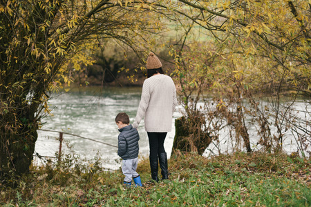 Mother and her child standing by the river in autumnの写真素材
