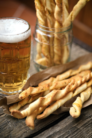 Homemade grissini with a glass of a cold beerの写真素材