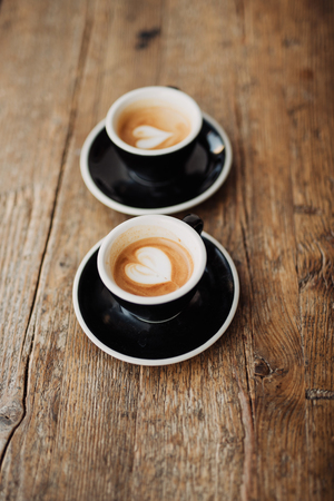 Two cups with coffee on wooden background の写真素材