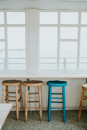 The empty cafe with wooden chairs by the window