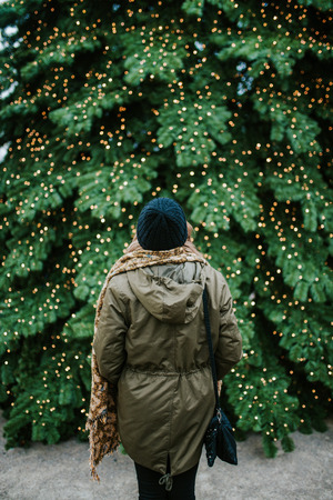Woman standing in front of big Christmas treeの写真素材