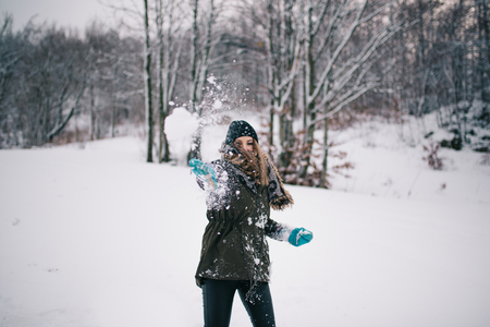 Happy woman throwing snowballの写真素材