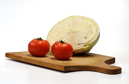 cabbage and tomato on wooden plateの写真素材