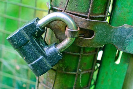  padlock  The closed old lock, hanging on a fenceの写真素材