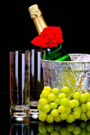 Champagne flutes in ice bucket, glasses and  grapeの写真素材