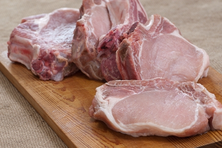 Fresh raw pork on board and knifeの写真素材