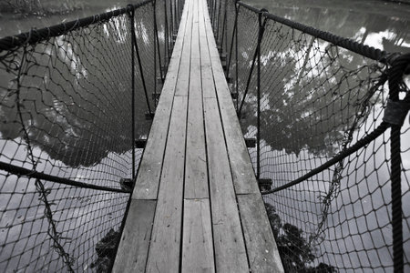 Black and white. Long hanging bridge cross the lake.の写真素材