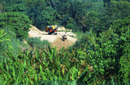 Sand dredging machinery in the middle of a forest area near the river