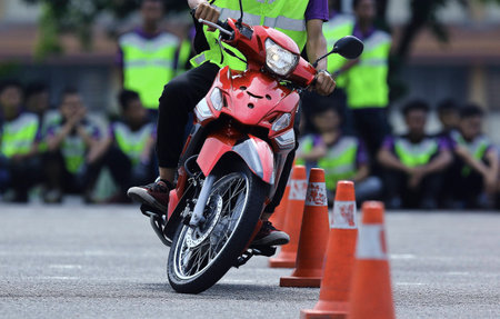 Person learning the skills of motorcycles using cone at open area