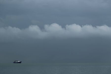 The boat stopped in the middle of the ocean at duskの写真素材