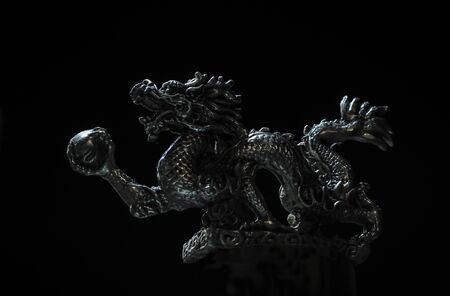 Close up. The design of a Dragon is made of bronze with a dark backgroundの写真素材