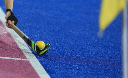 Hands holding a hockey stick control the ball on the fieldの写真素材