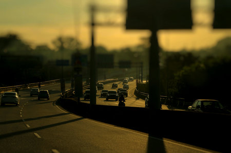Silhouette tone. Vehicles moving on a road in the evening