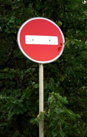 Old Forbidden Traffic Sign against trees